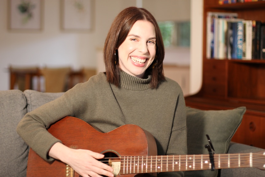 Helen laughing, holding guitar