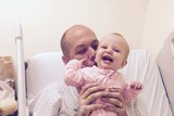 Adam Harvey with his daughter Isla in hospital after having a bullet removed from his neck