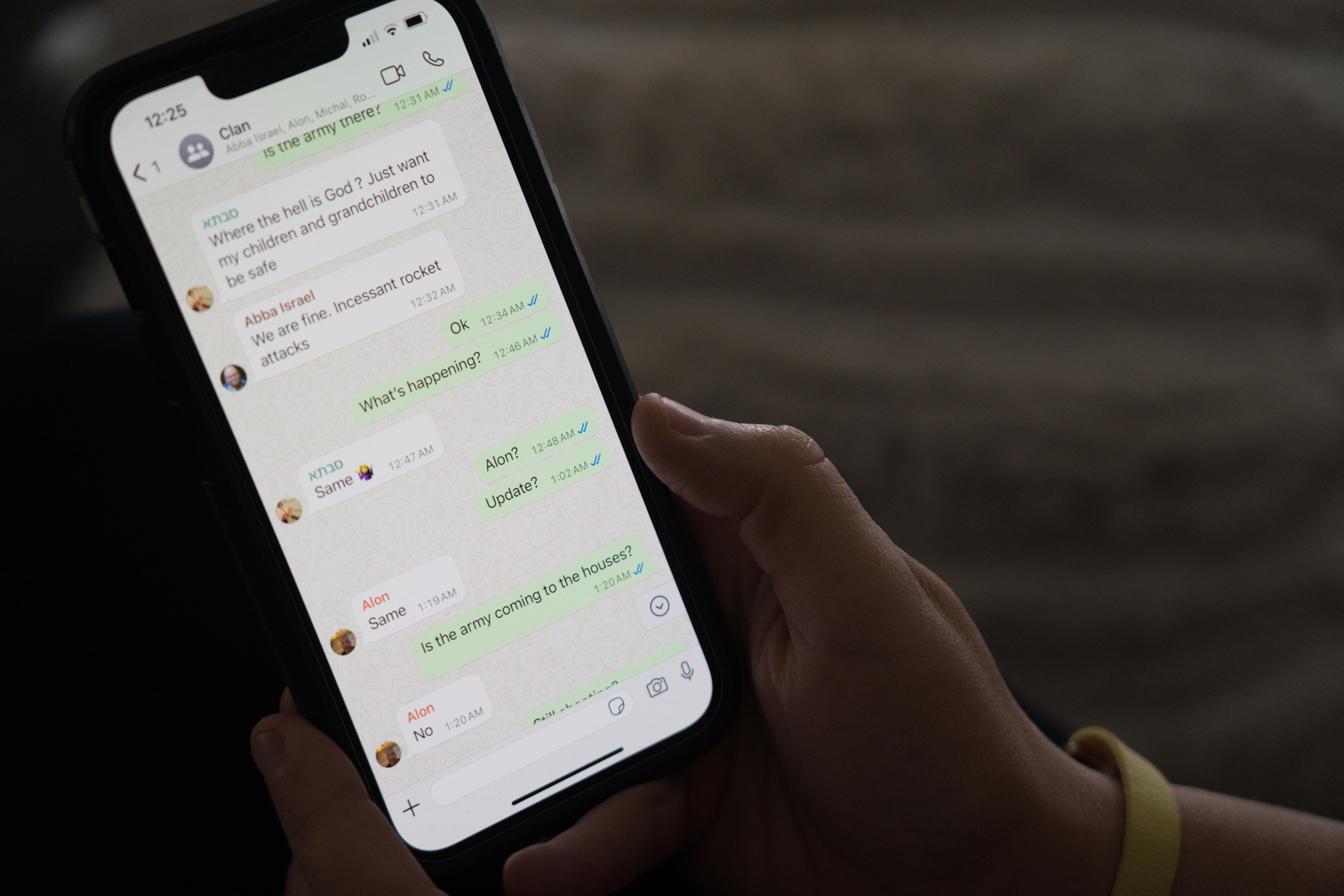 A hand showing a phone displaying whatsapp messages