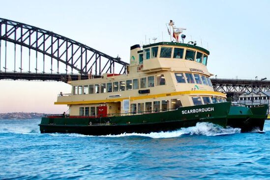 a ferry on the water travelling with passengers past the harbour bridge