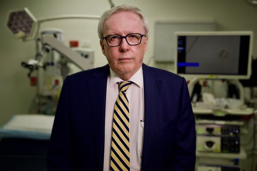 AMAQ President Chris Perry stands in a hospital room.