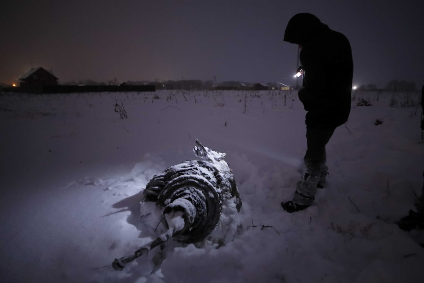 A man stands near part of the plane that crashed after taking off from Moscow's Domodedovo airport on February 11, 2018.