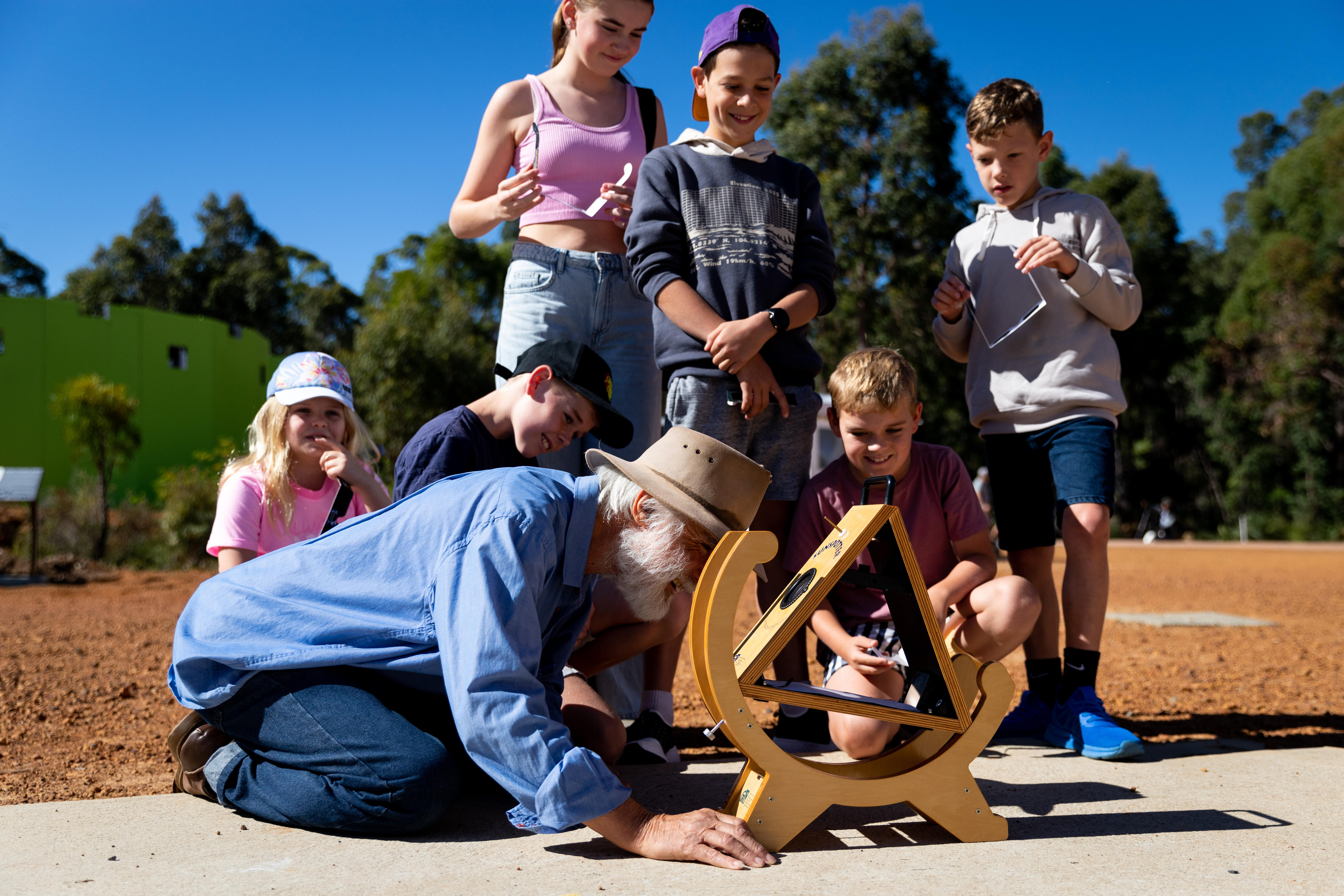 A crowd of people around a specialised eclipse viewing scope
