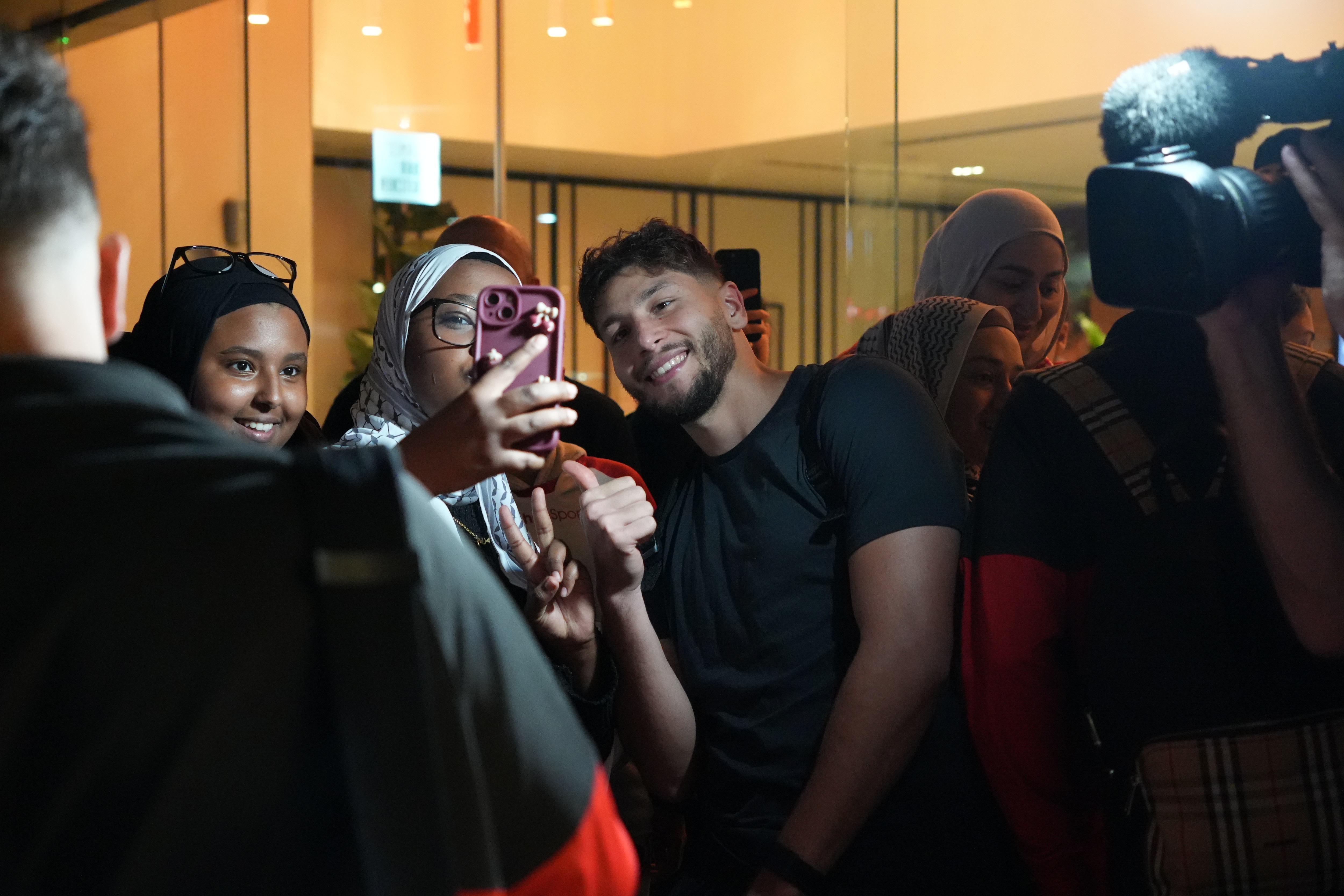 Fans take pictures with football players.