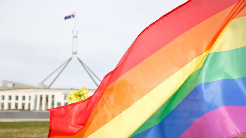 A rainbow flag flies out in front of Parliament House, Canberra