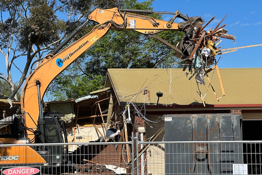 Debris from the old Inglewood ambulance station in the grips of demolition machinery.