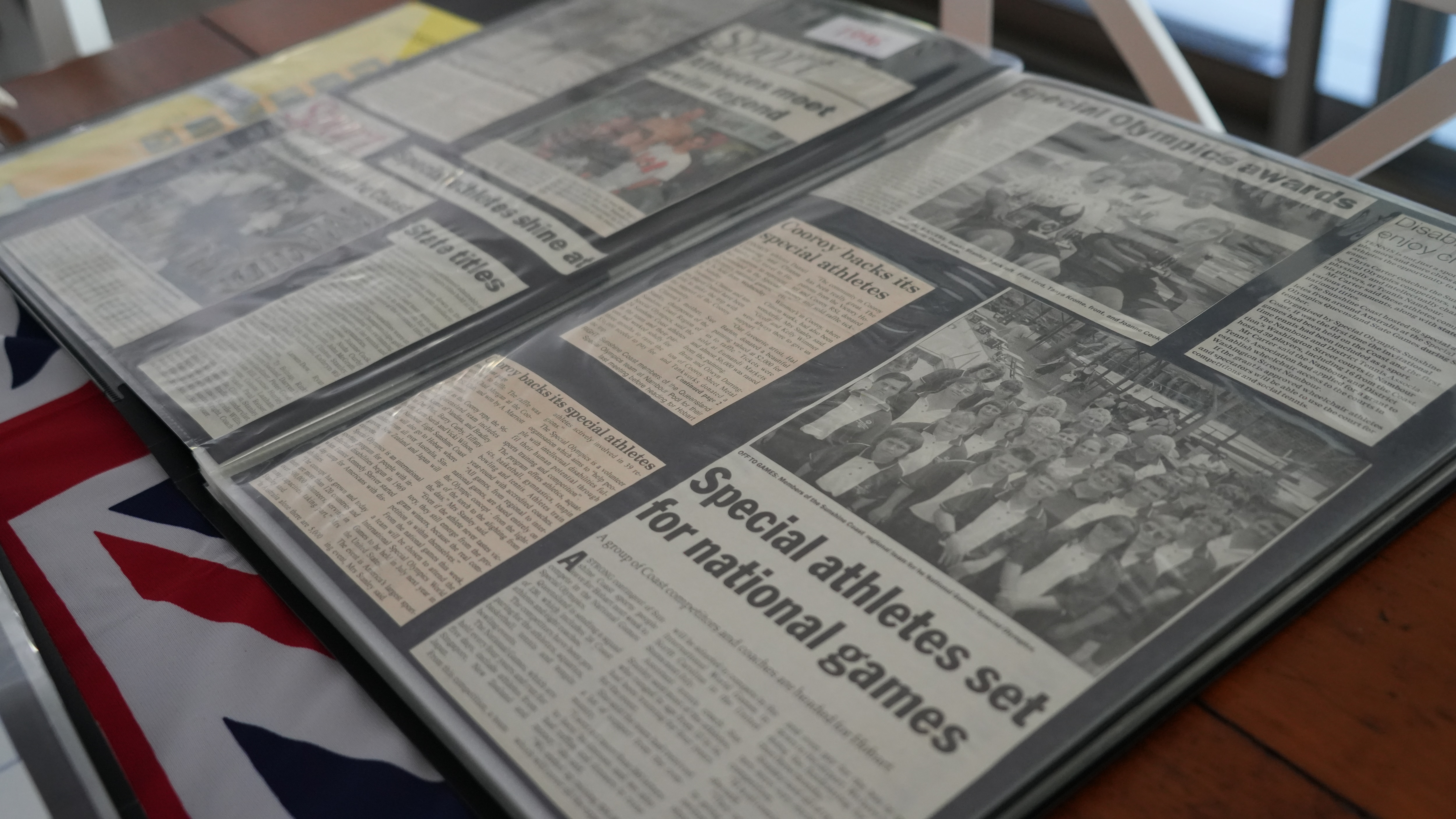 An A3 folio book opened to a double page full of newspaper clippings.