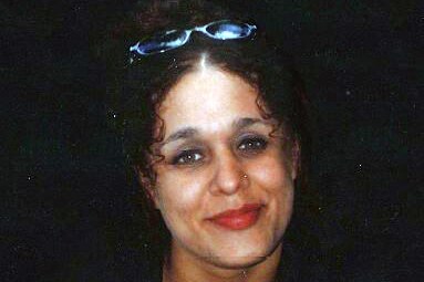 A head and shoulders photo of Rebecca Delalande, smiling and with sunglasses on her head.