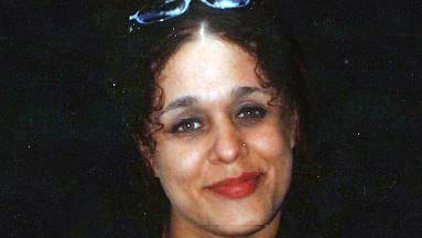 A had and shoulder photo of Rebecca Delalande, smiling and with sunglasses on her head.