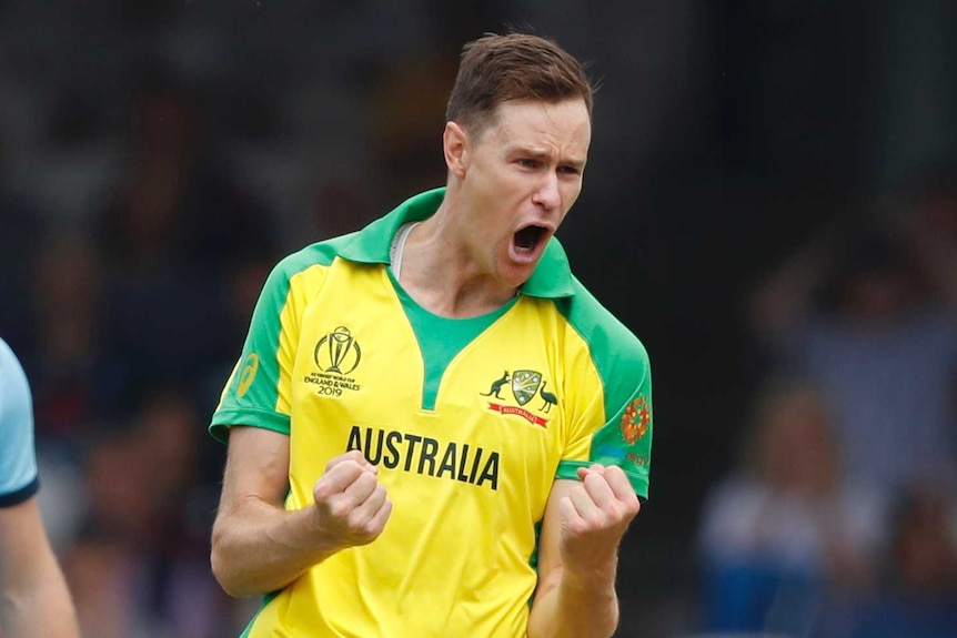 Australian bowler Jason Behrendorff pumps his fists in celebration as England batsman Jonny Bairstow looks on from behind.