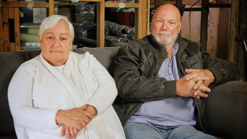 Elderly man and woman sitting on a couch.
