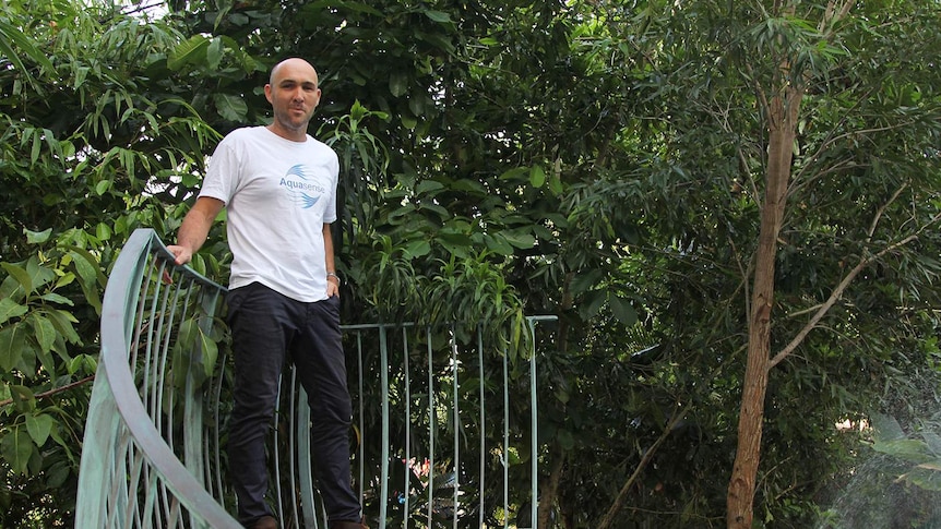 Entrepreneur Michael Bruvel standing next to his above-ground pool in an Aquasense t-shirt.