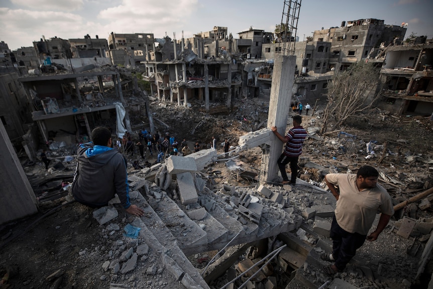 Palestinians inspect their destroyed homes following Israeli airstrikes in Beit Hanoun