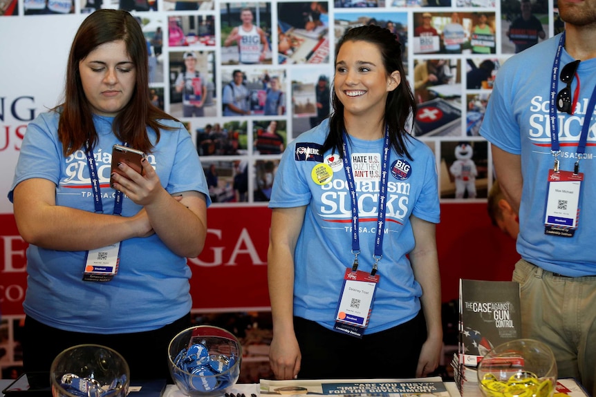 Volunteers at the Turning Point USA booth wait to speak with people at the conference
