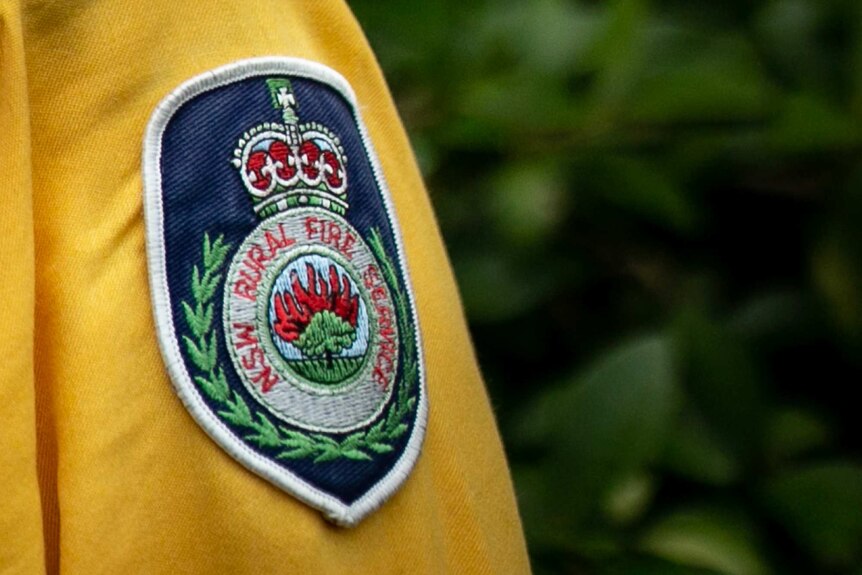 A cloth badge on the side of a uniform that says "NSW Rural Fire Service"