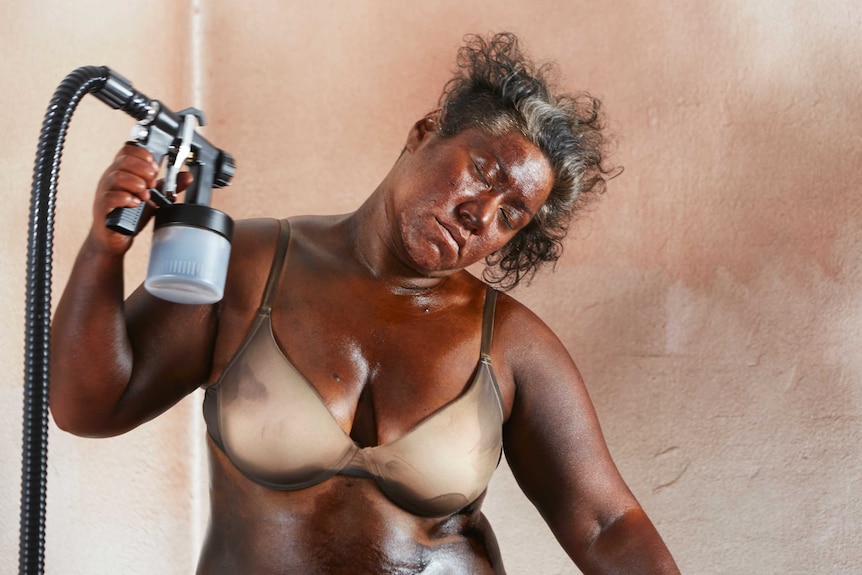 The performance artist Latai Taumoepeau, spray tanning her already dark skin to be darker in the artwork Dark Continent