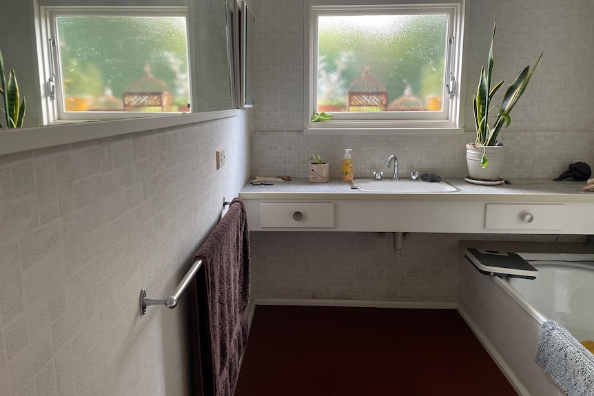 Bathroom with bench sink, original draws and mirror wall. 