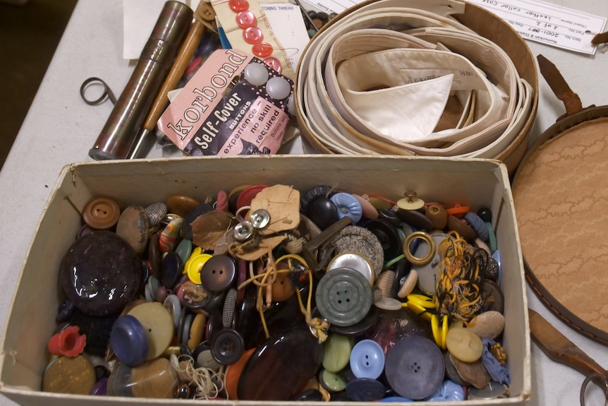 a rectangle box filled with multi coloured buttons and a circle box filled with rolled out collar patterns 