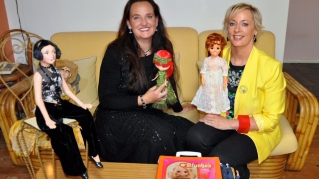 Two women and a few dolls on a couch