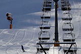 A skier speeds down the slope besides an empty chairlift in the Austrian province of Tyrol.