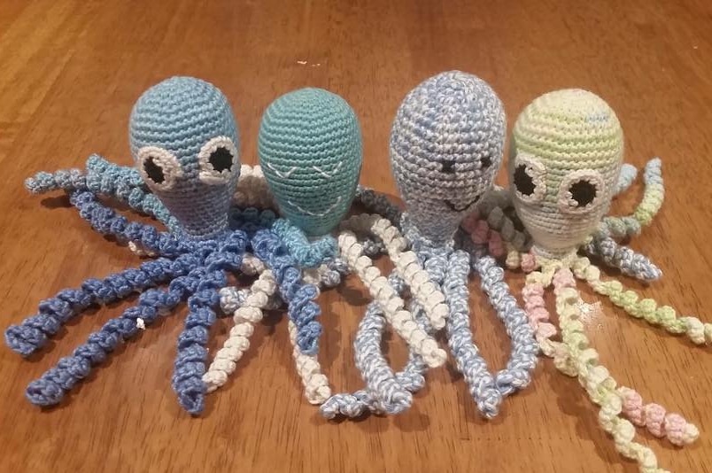 Four crocheted octopuses on a table