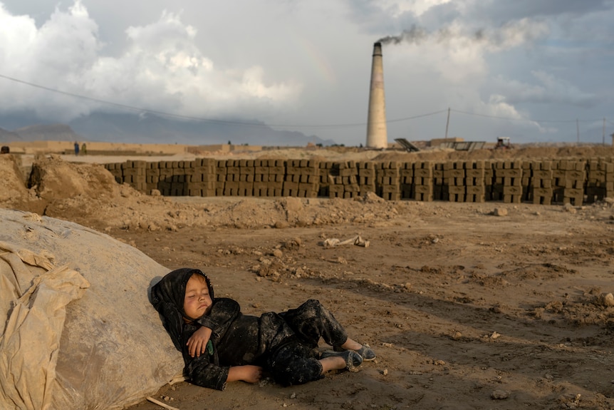 A 4-year-old Afghan girl sleeps outside in a brick factory 