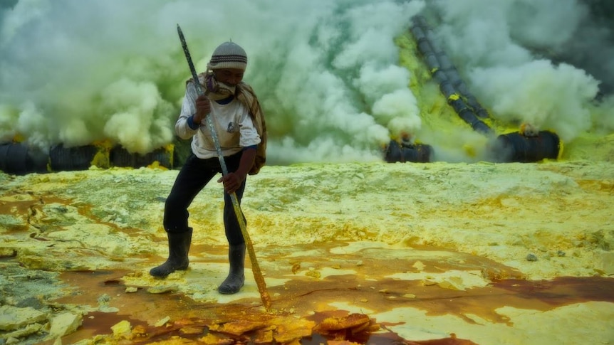 A miner prods for solidified sulphur on a tenuous crust.