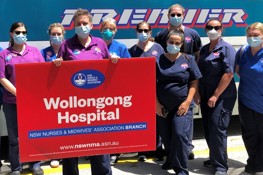 Group of people wearing navy scrubs and blue face masks