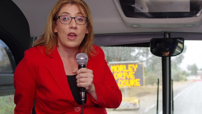 Opposition transport spokeswoman Rita Saffioti playing tour guide on a bus trip holding a microphone.