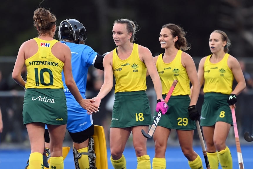 Four Hockeyroos players shake hands among themselves after beating New Zealand.