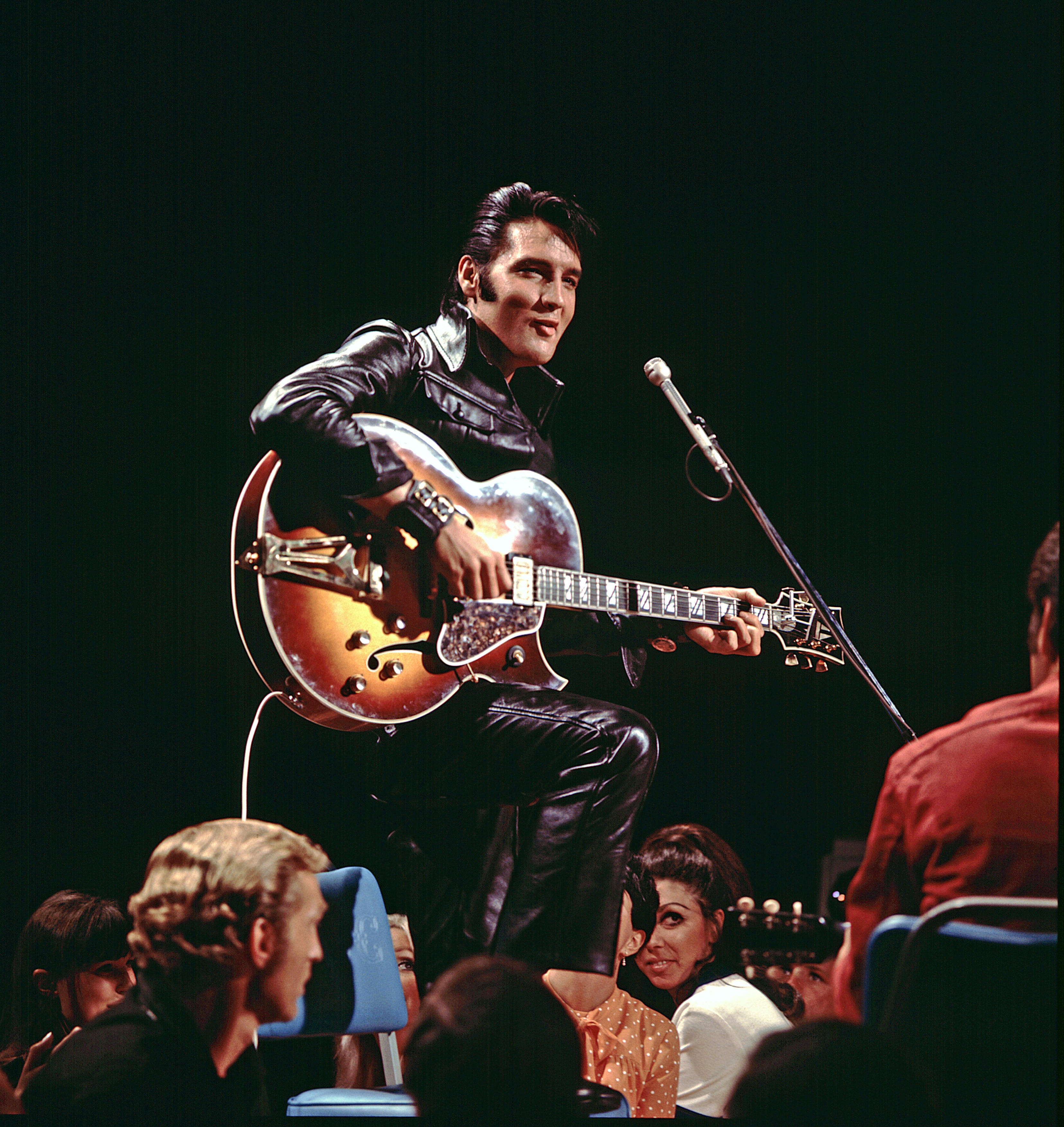 Elvis en el escenario tocando detrás de una guitarra