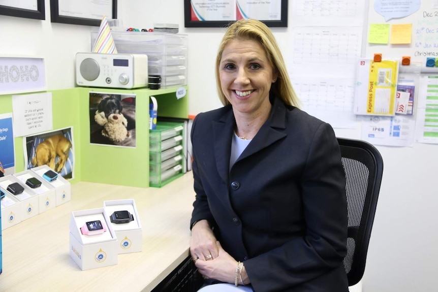 Karen Cantwell sitting at her desk smiling with TicToc Track watches by her side.