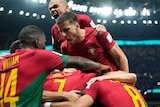 A group of Portuguese footballers pile on top of Cristiano Ronaldo after a goal against Uruguay.