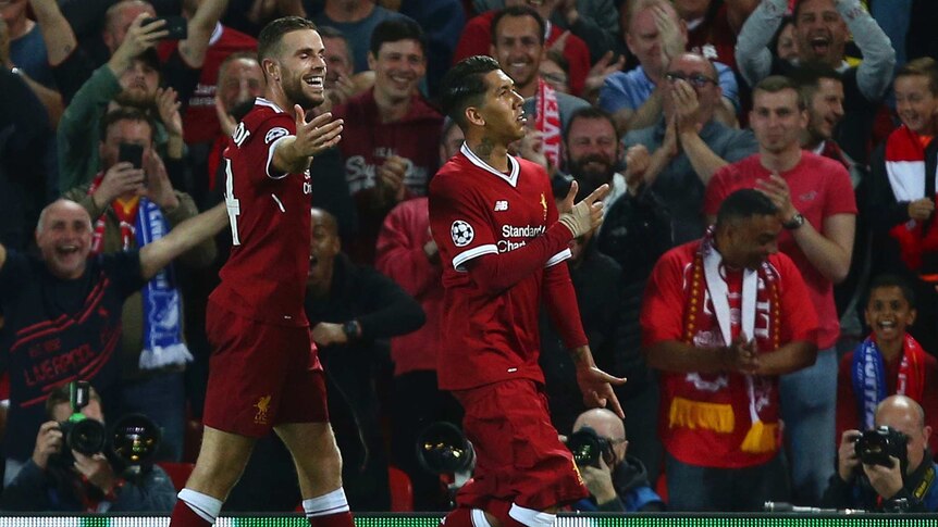 Liverpool's Roberto Firmino (R) celebrates scoring against Hoffenheim at Anfield.