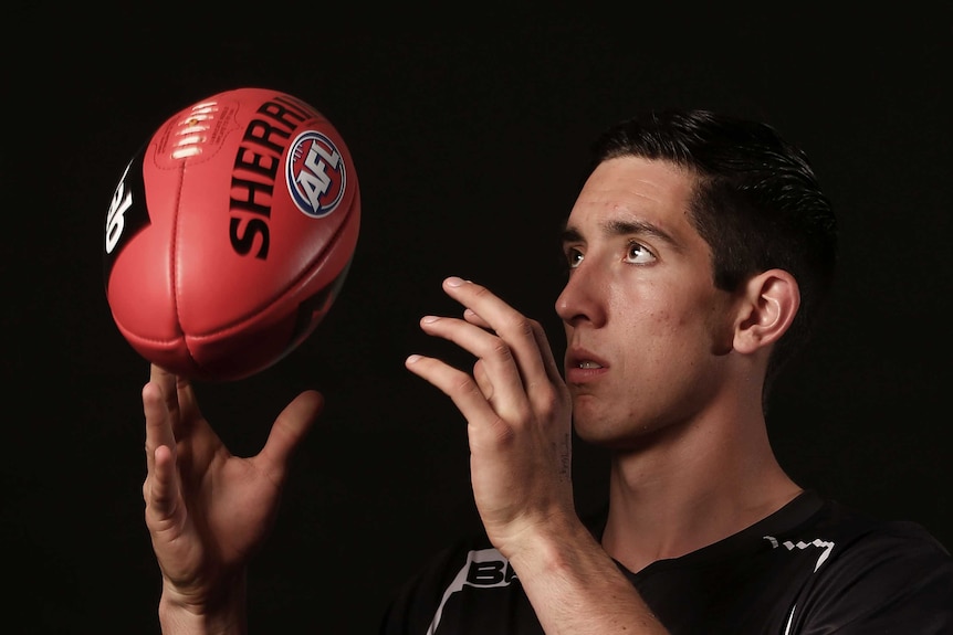 Jacob Weitering looks at an AFL ball