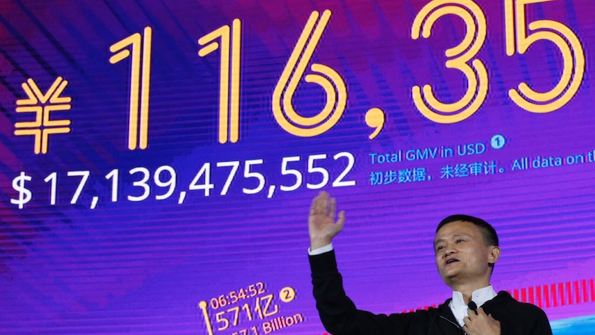 Jack Ma points to sales figures on a big screen behind him. The figure says $17,139,475,552