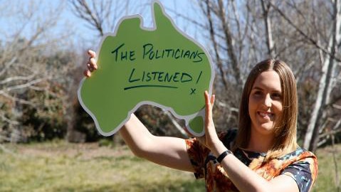 Teenage girl holds up sign in shape of Australia, text reads "The politicians listened!"