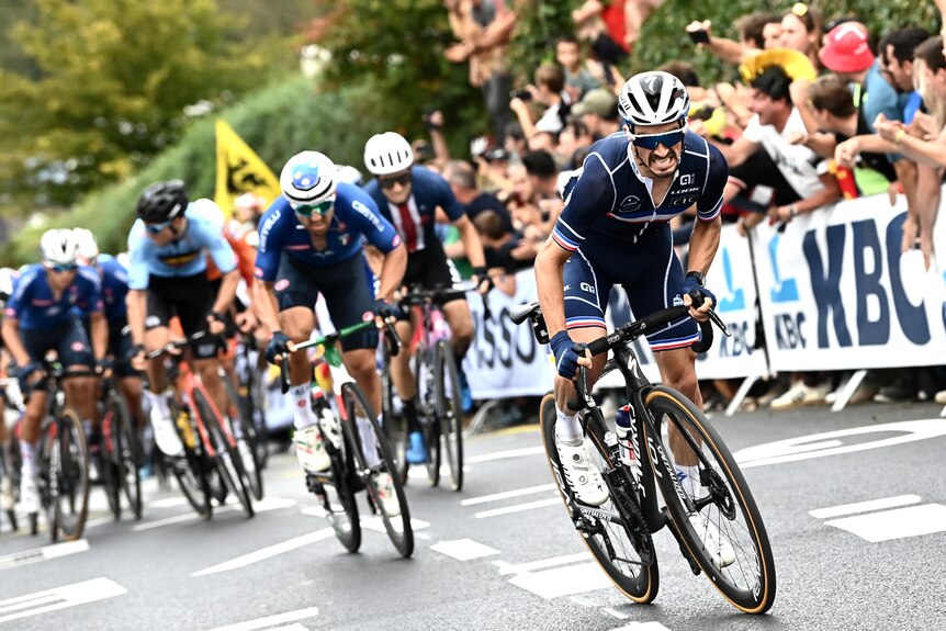 Julian Alaphilippe powers up a hill with cyclists behind him