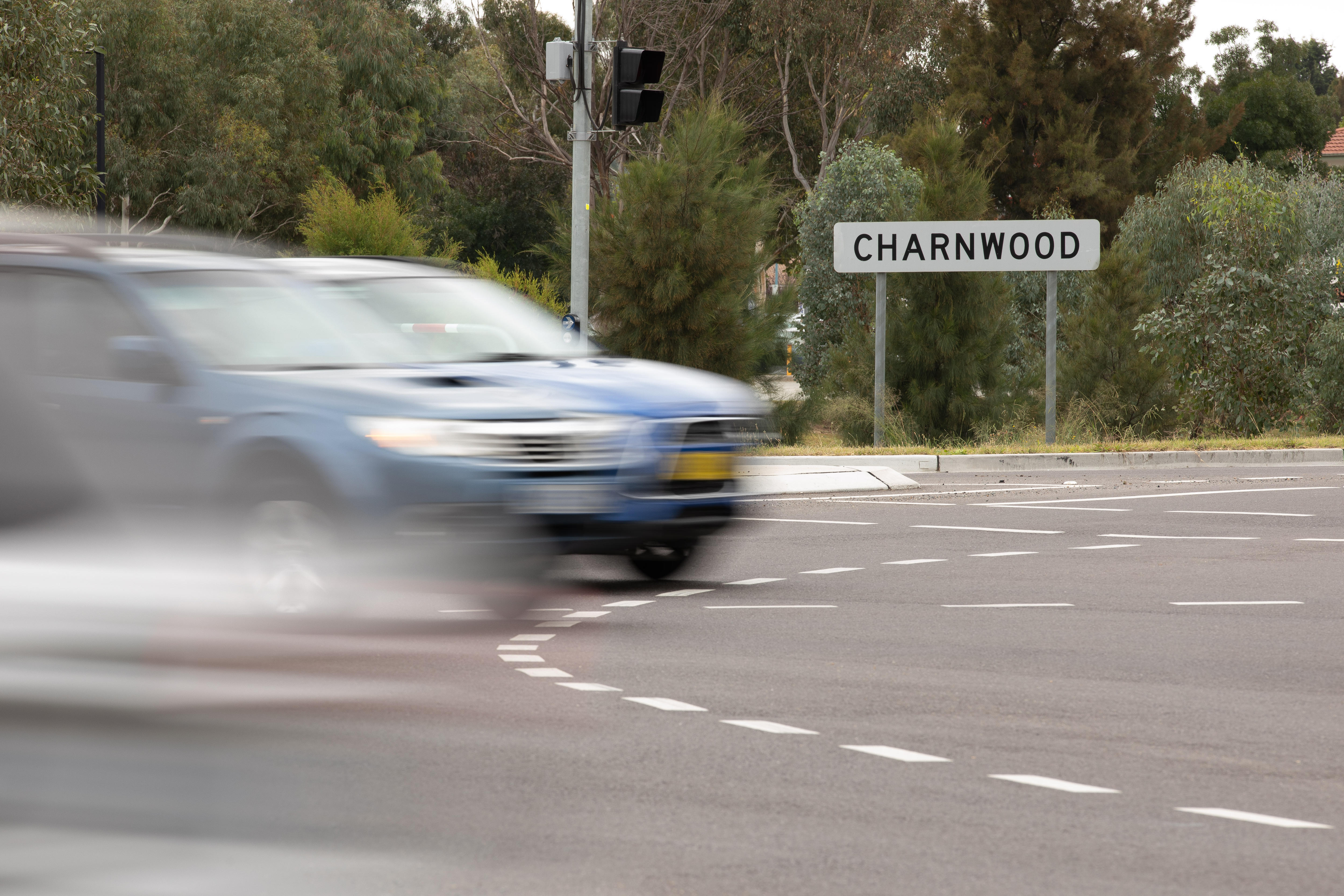 A grey car drives past a Charnwood sign.