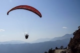 A paraglider flies through the Pokhara region.