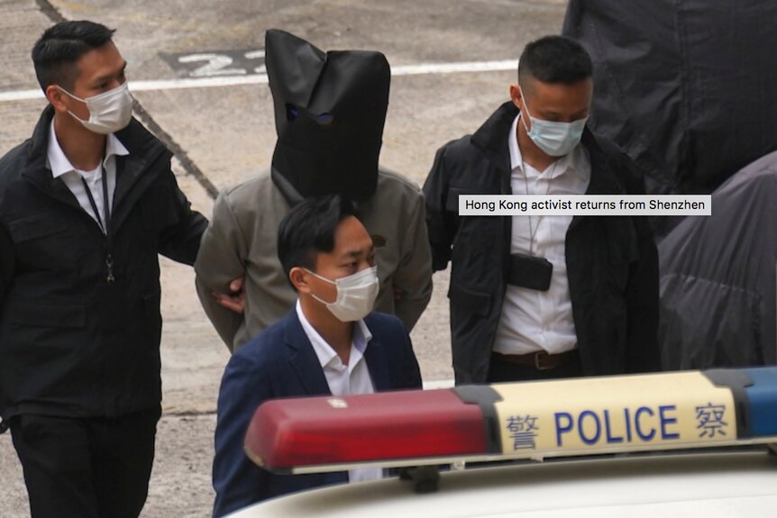 12名香港活跃人士中的一位从深圳抵达香港天水围警察局。