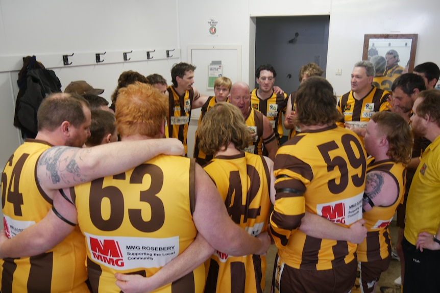 A group of football players in a huddle.