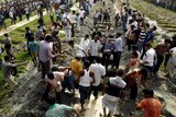 Bangladeshis bury the remains of garment workers killed in the garment factory collapse.