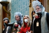 Women wearing gas masks and face masks in the House Chamber at the US Capitol.