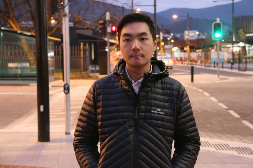 Student Kevin Alexander stands next to main road in Glenorchy.