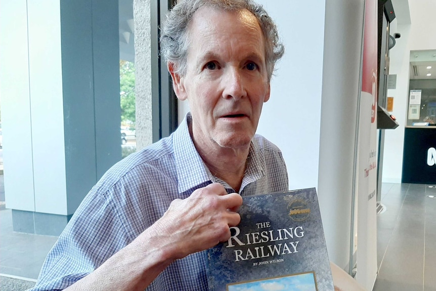 Author John Wilson holds a book.