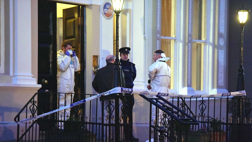 Police and forensic officers attend the scene of the shooting in Dublin