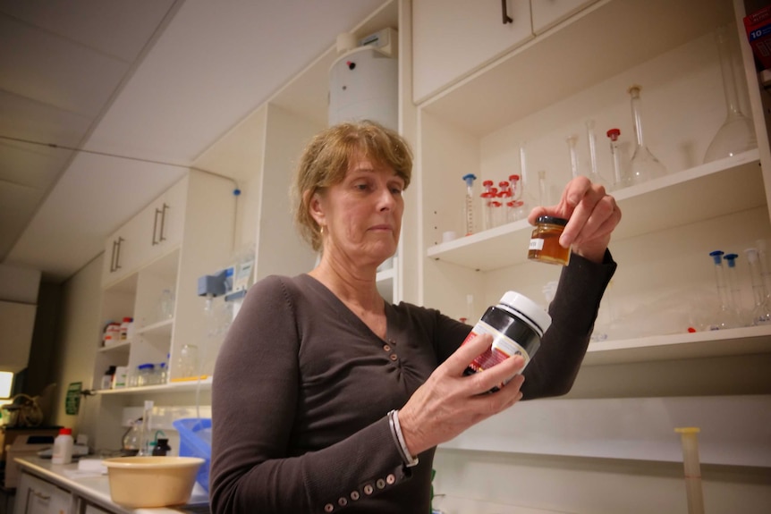 Dr Liz Barbour holds a honey jar at UWA in June 2020.