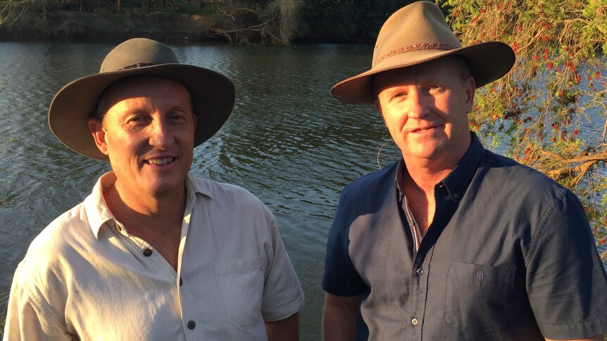 Rod Bruem and Phil Terry smile for the camera in front of a river