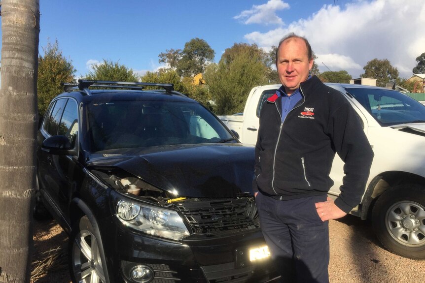 Panel beater Glenn Umbers standing in front of car